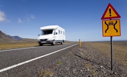 "Motor Home Driving On An Open Road With Danger Sign"